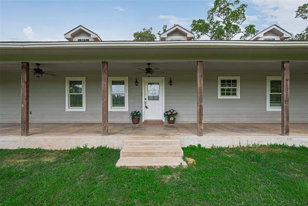 A short set of steps leads up to the expansive front porch, complete with ceiling fans for comfortable lounging in any weather.