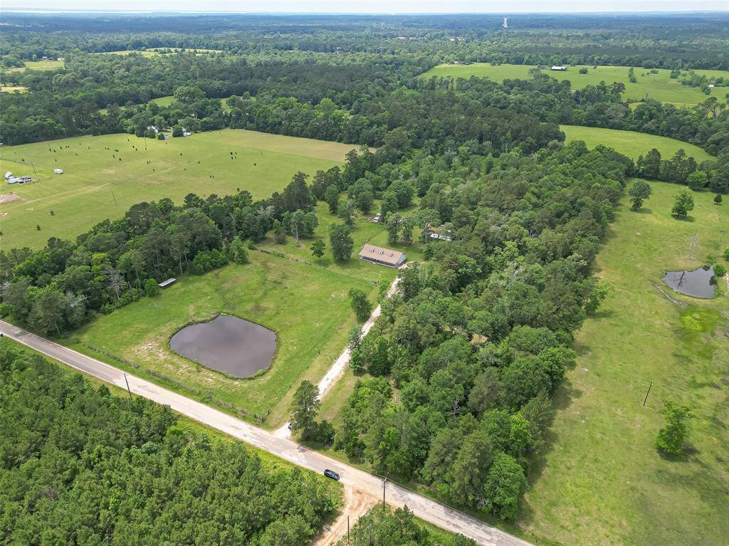 From above, the property’s full scope comes into view—10 acres of both open land and wooded surroundings, complete with a pond nestled into the landscape.