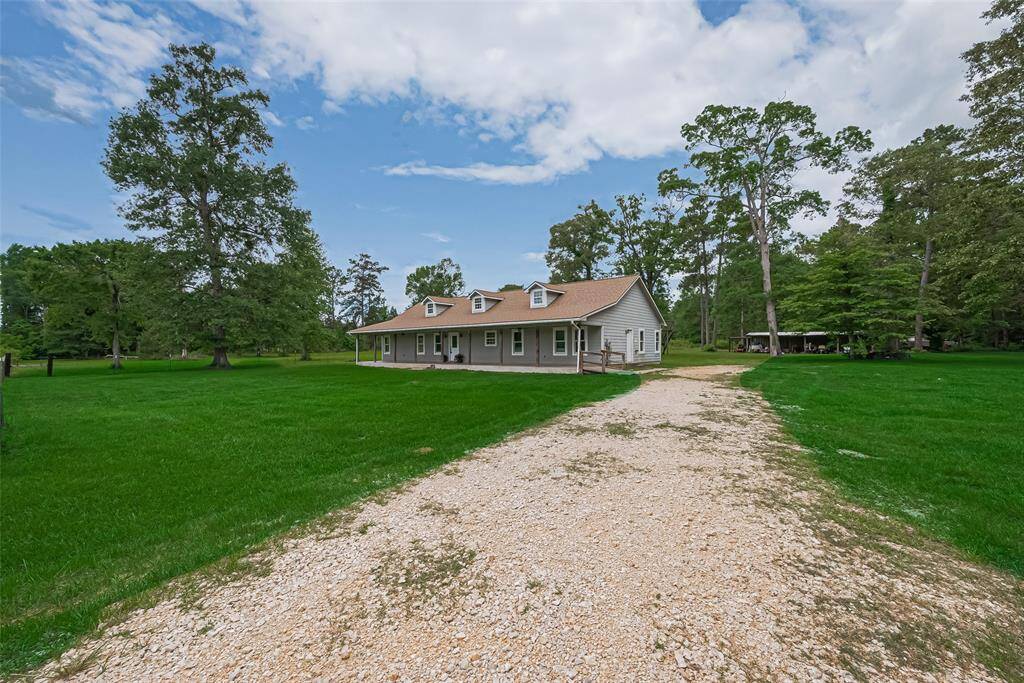 A long path leads to the home, meandering through the open grassy expanse.
