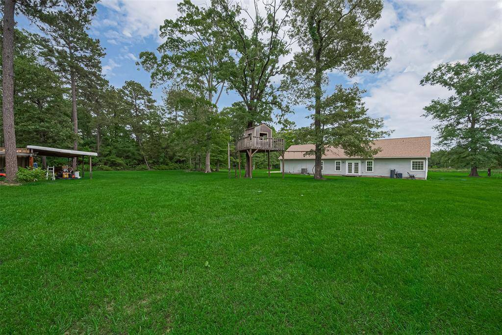 From the backyard, a tree house and a large open shed add utility and charm to the wide grassy yard.