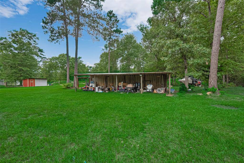 Tucked among mature trees, the large open shed offers shelter and storage while blending into the landscape.