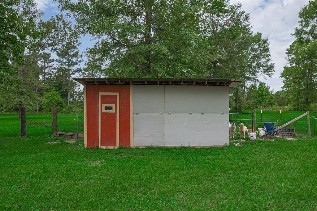 Positioned near a fenced area is a laying hen chicken coup with drop down sides for the summer.