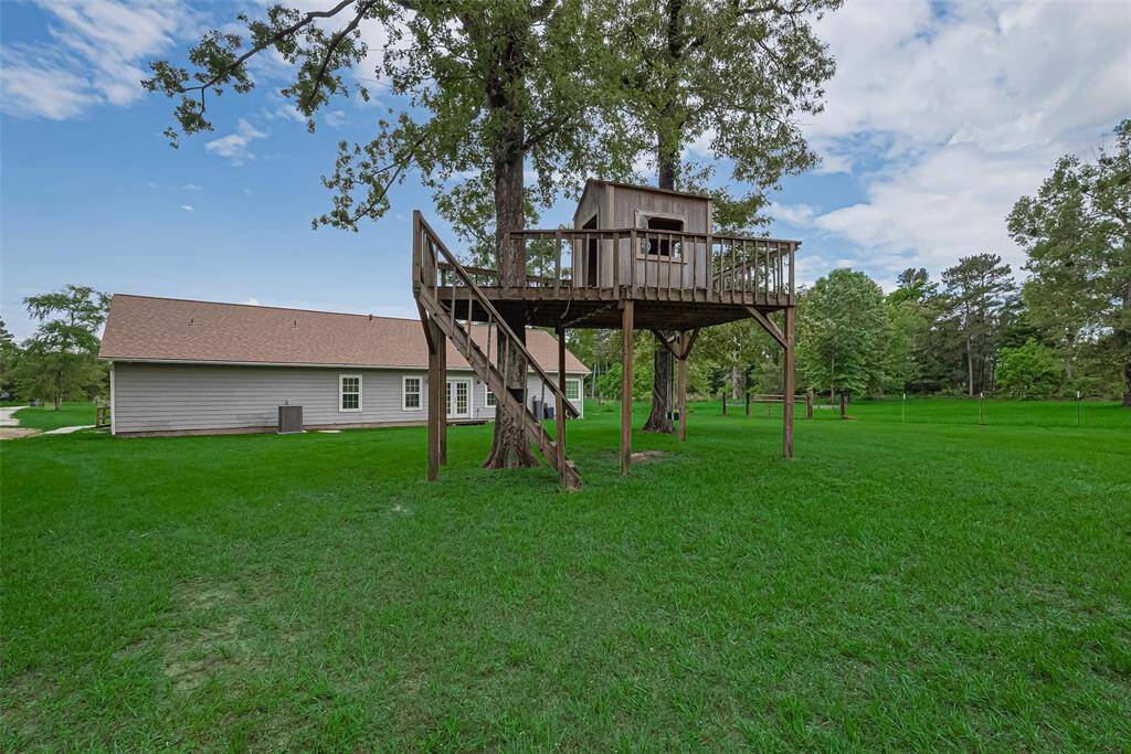 A delightful elevated deck invites play or quiet retreat, adding charm to the backyard’s rear view.