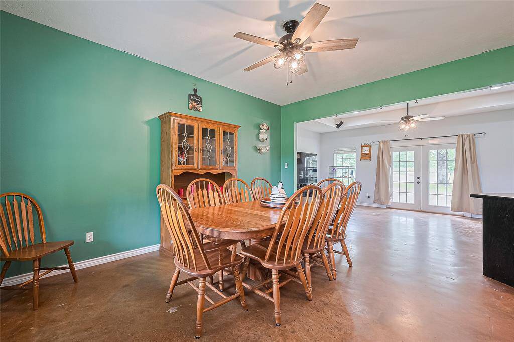 The dining space is beautifully connected to the living room, with warm lighting and a ceiling fan above.