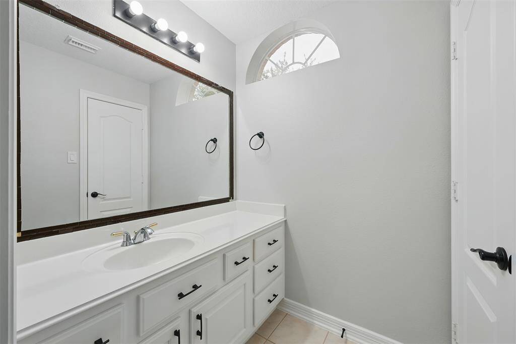 Bright and inviting upstairs bathroom featuring modern fixtures, a spacious countertop, and ample natural light.