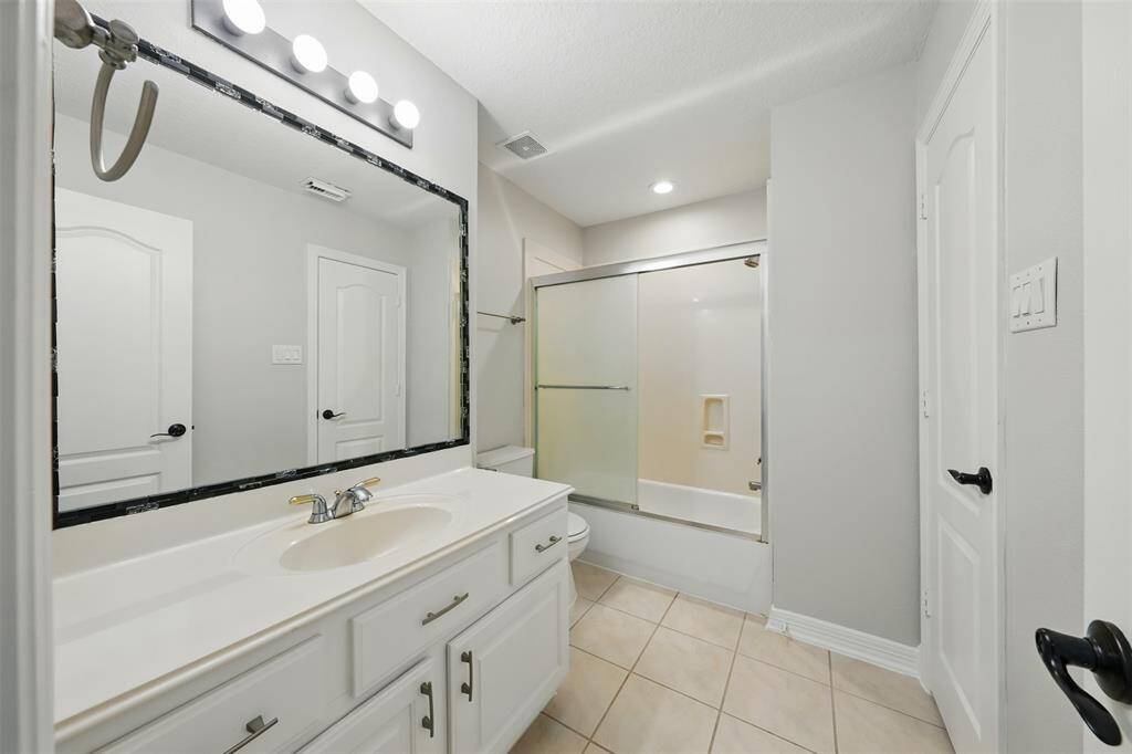 Bright and inviting upstairs bathroom featuring modern fixtures, a spacious countertop, and ample natural light.