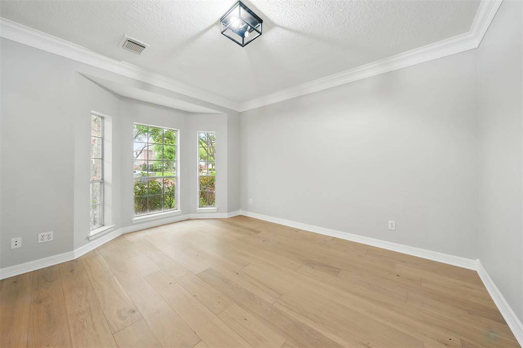 This versatile living room offers the perfect space for a cozy study or home office.