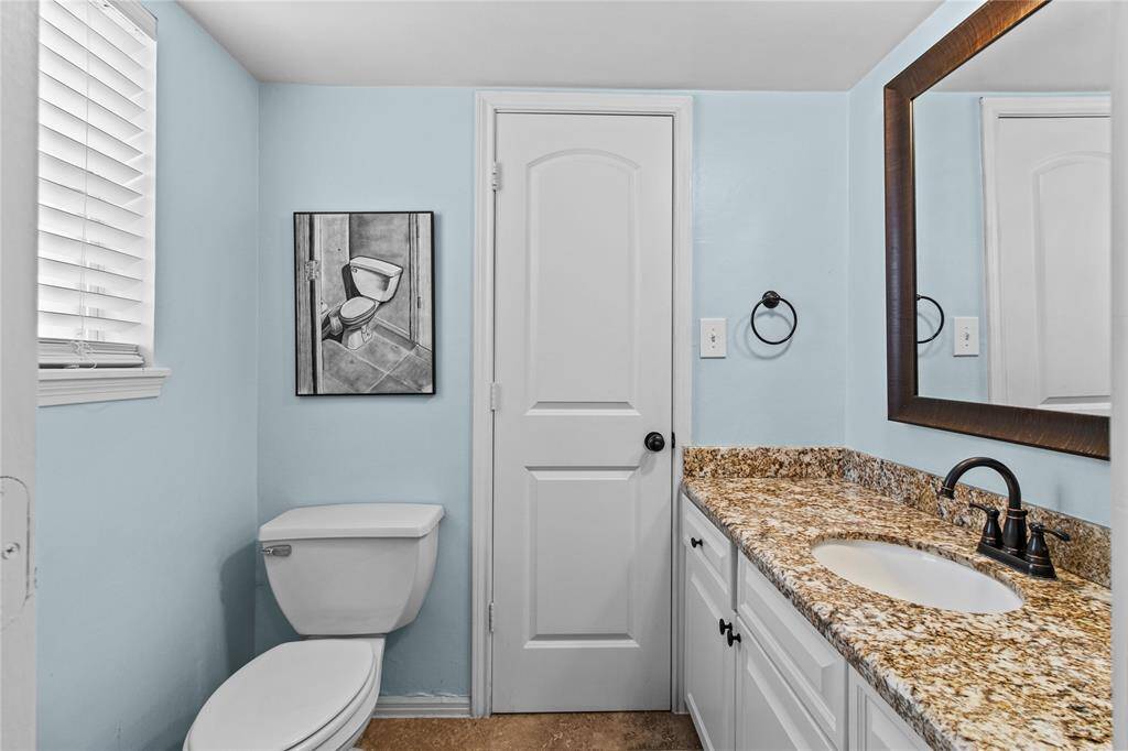 The half bath is located behind the wet bar area and can be accessed by the living room or the utility room.