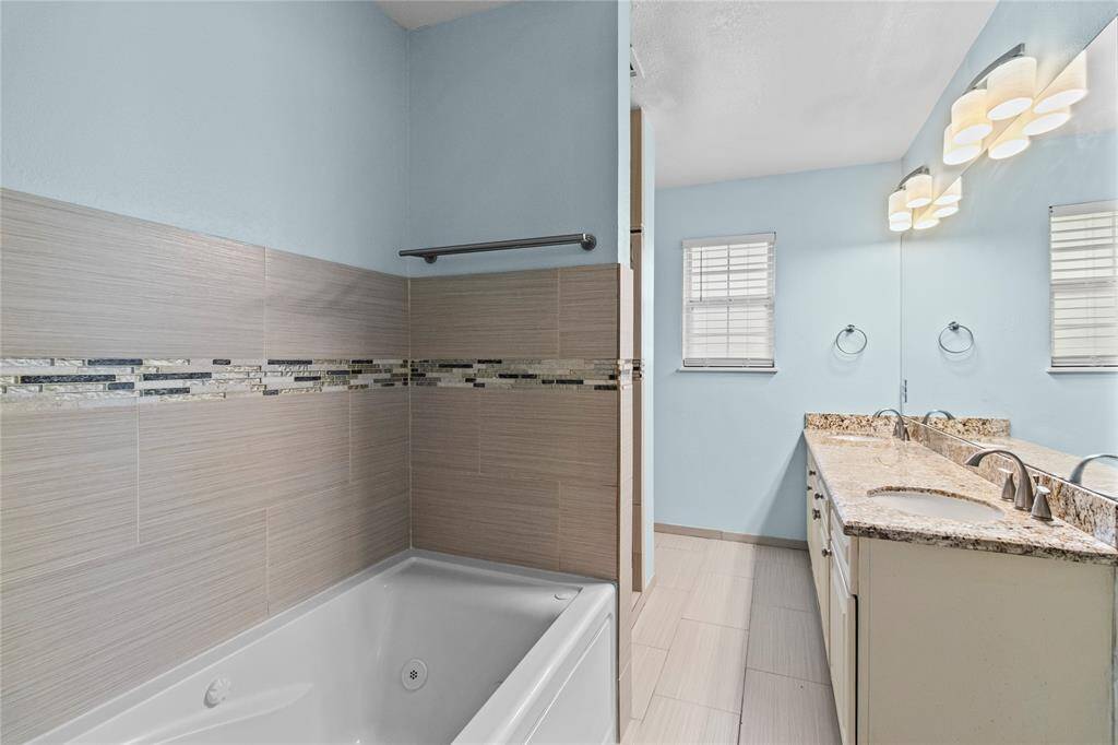 The primary bathroom has granite counter tops and double sinks.