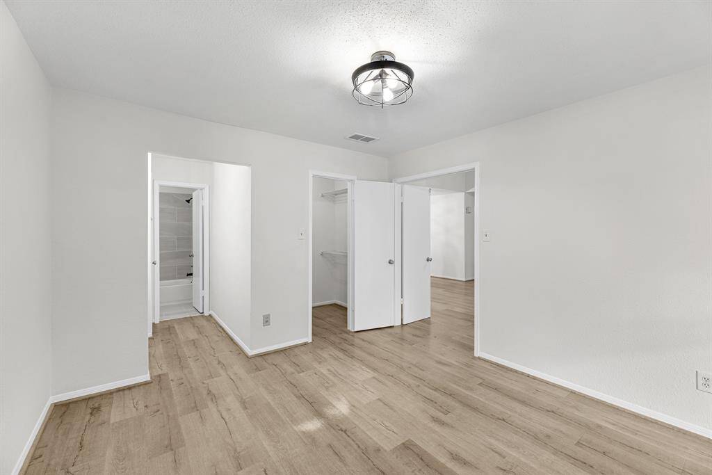 Bright, spacious room with laminate wood flooring and fresh paint. It features a modern ceiling light fixture, private updated bathroom and a walk-in closet. Ideal for a bedroom or office space.