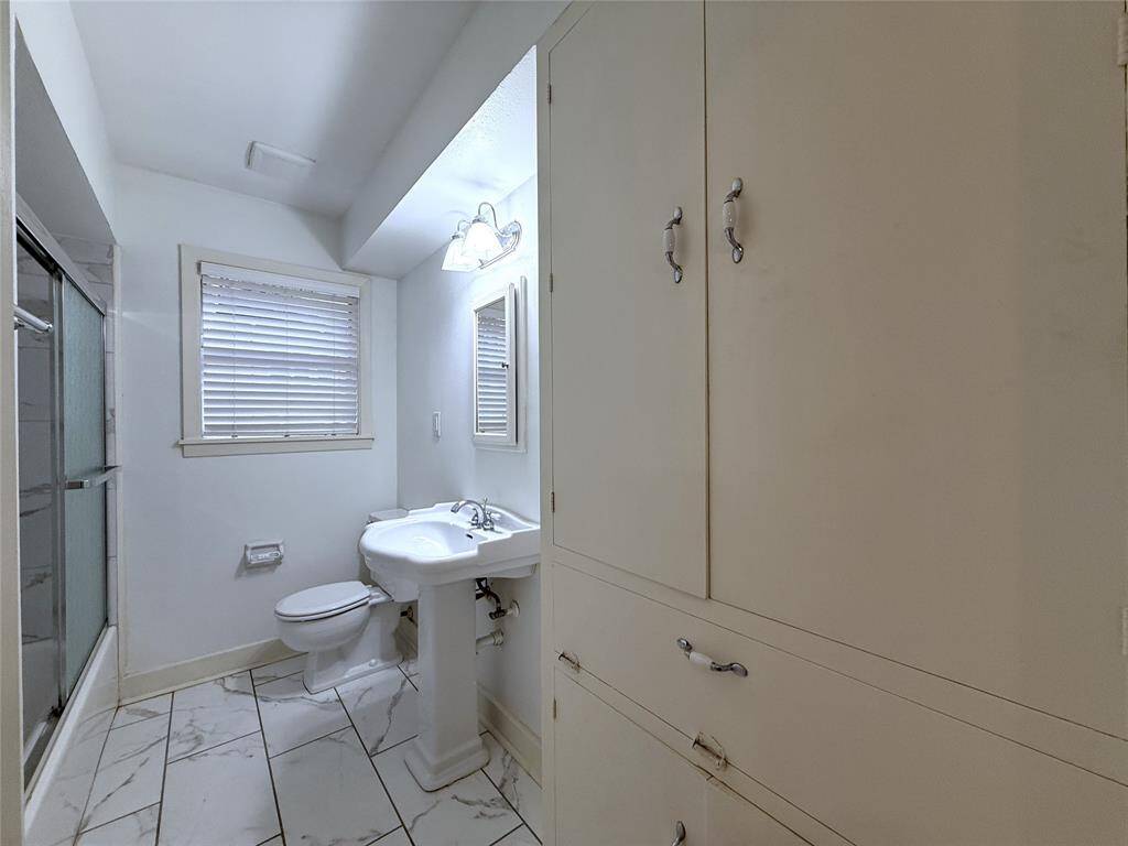 The hallway bath with tub/shower combo, linen closet & built-in hamper.