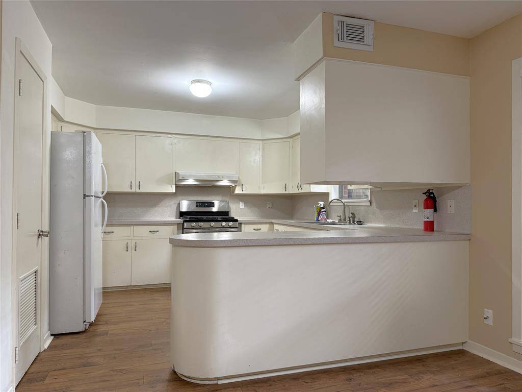With breakfast bar, the wrap-around kitchen is light & bright. Behind the door on the left is a pantry.