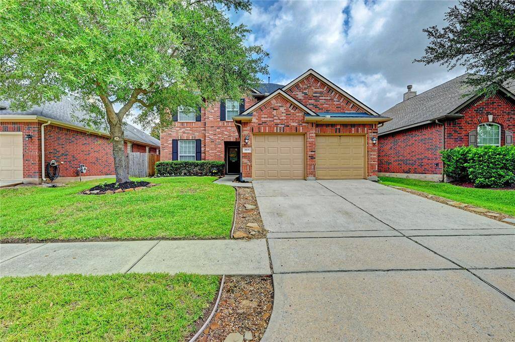 Charming brick home with a two-car garage, surrounded by well-maintained landscaping. Features a spacious driveway and a lush front lawn, offering great curb appeal in a quiet neighborhood.