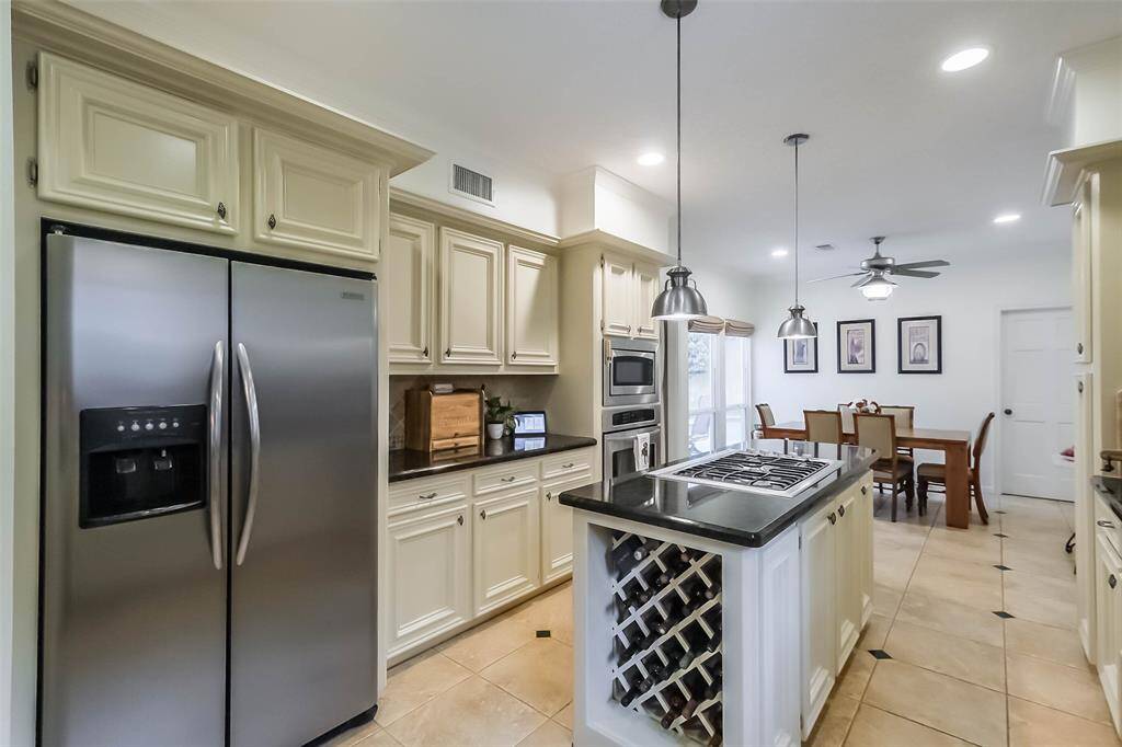 The focal point is a sleek island that has a gas cooktop and wine storage area.