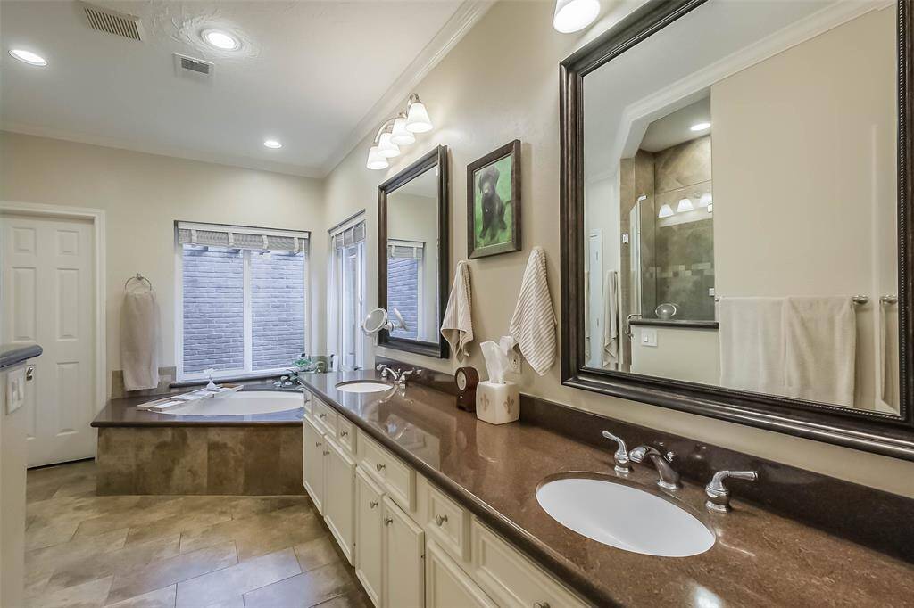 The primary bathroom features dual sinks, tile floors, large windows, and a separate tub.