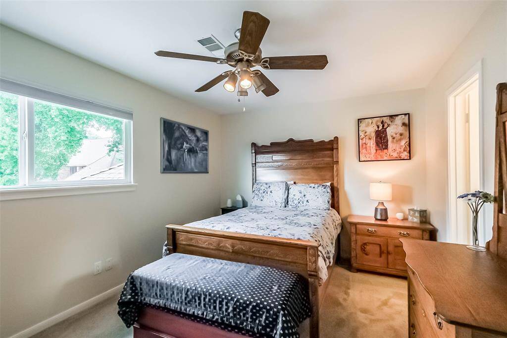 Third bedroom features awindow, walk-in closet, ceiling fan, and plush carpet.