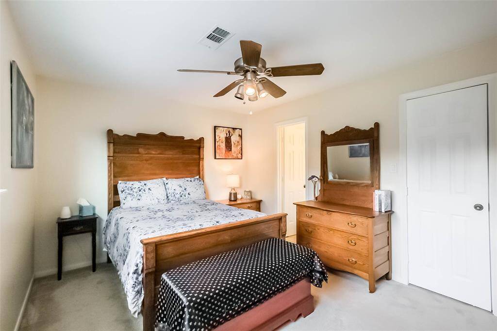 Third bedroom features awindow, walk-in closet,ceiling fan, and plush carpet.