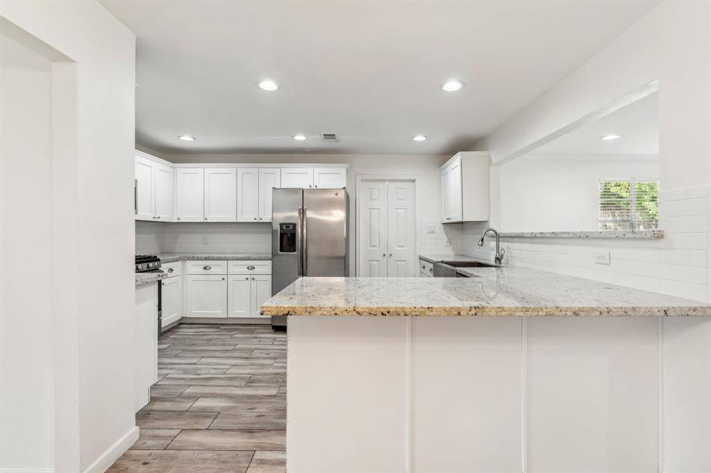 This kitchen blends practicality and style with granite countertops, abundant cabinet space, and a breakfast bar that invites casual dining or conversation. The open layout keeps everything within reach for easy hosting.
