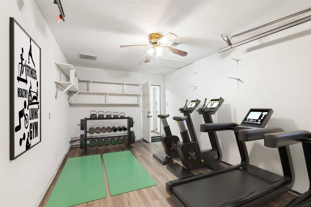 **Virtually Staged** Air-conditioned garage is perfect for a home gym, home business, or creative studio. Built-in shelves offer convenient organization.