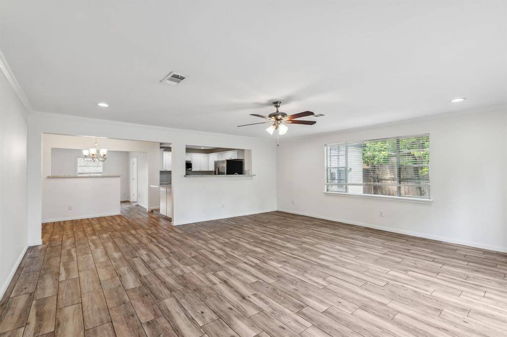 With its open access to the kitchen and dining areas, the living room serves as a central hub for entertaining or everyday comfort. Recessed lighting and crown molding add a polished finish throughout.