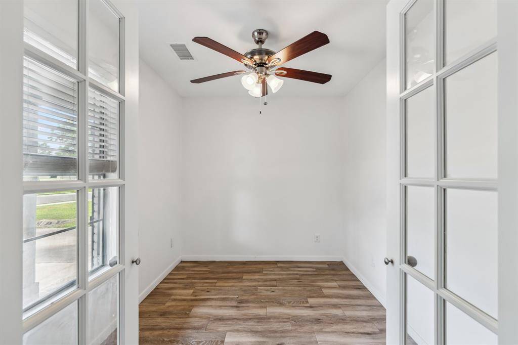 Formal Office framed by glass-paned French doors that add character while letting in natural light.