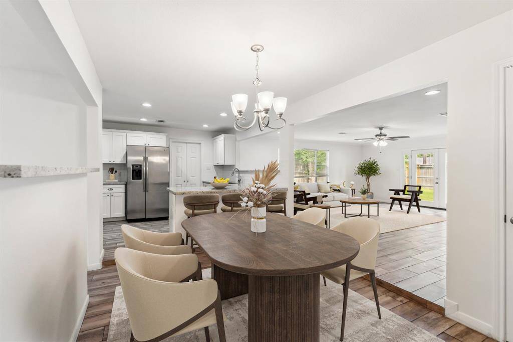 **Virtually Staged** The open-concept layout connects the dining area to both the kitchen and large living room, making the space ideal for gatherings. A transitional step down subtly defines each space while maintaining visual flow.