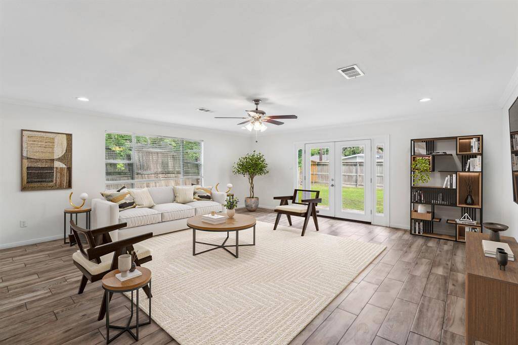 **Virtually staged** This expansive living area offers flexibility for multiple layouts, with large windows that bring in plenty of natural light. French doors open directly to the backyard, seamlessly blending indoor and outdoor living.