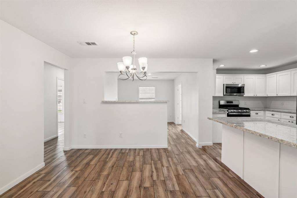 Enjoy casual meals or entertaining guests in the dining space, which offers a passthrough window to the kitchen and additional wall space for art or storage. Recessed lighting and modern fixtures add a polished touch.