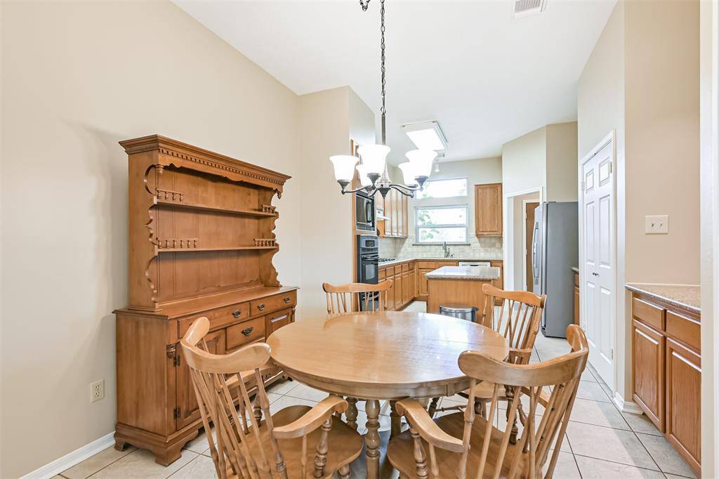 Open-concept design keeps the breakfast area connected to kitchen and den.
