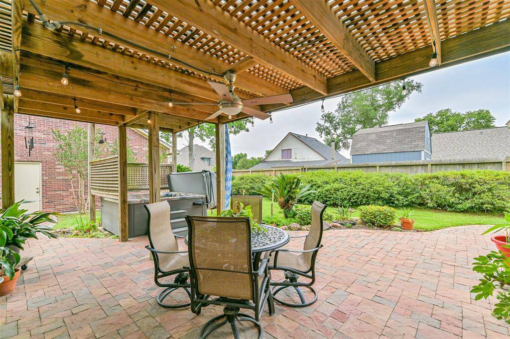 Pergola-covered patio offers shade and style for outdoor gatherings.