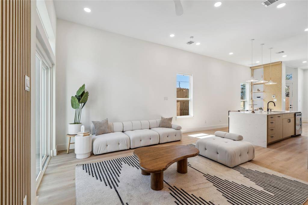A harmonious blend of kitchen, dining, and living areas creates a modern, multifunctional living experience.