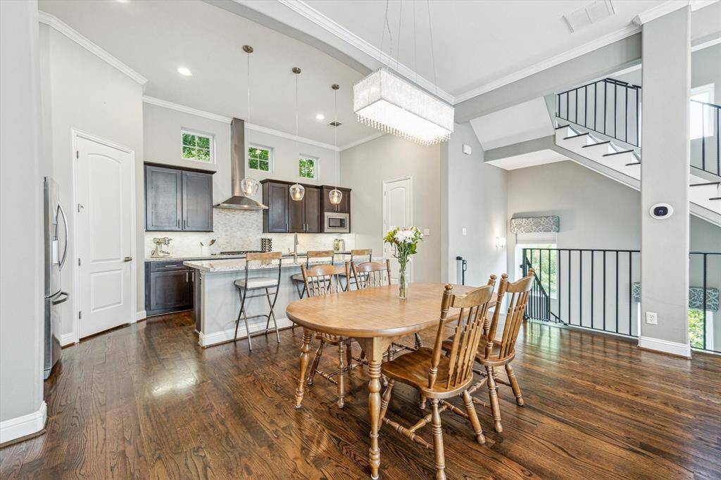 Gather them around your table in this inviting open dining area. With soaring ceilings, stylish lighting, rich hardwoods, and abundant natural, this thoughtful open design sets the stage for everything from festive celebrations to quiet evenings at home.
