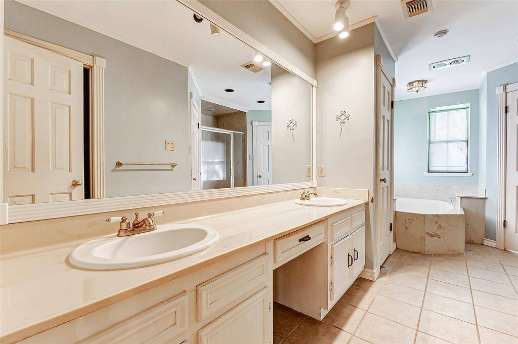 Primary bath with dual sinks, walk-in shower and separate soaking tub.