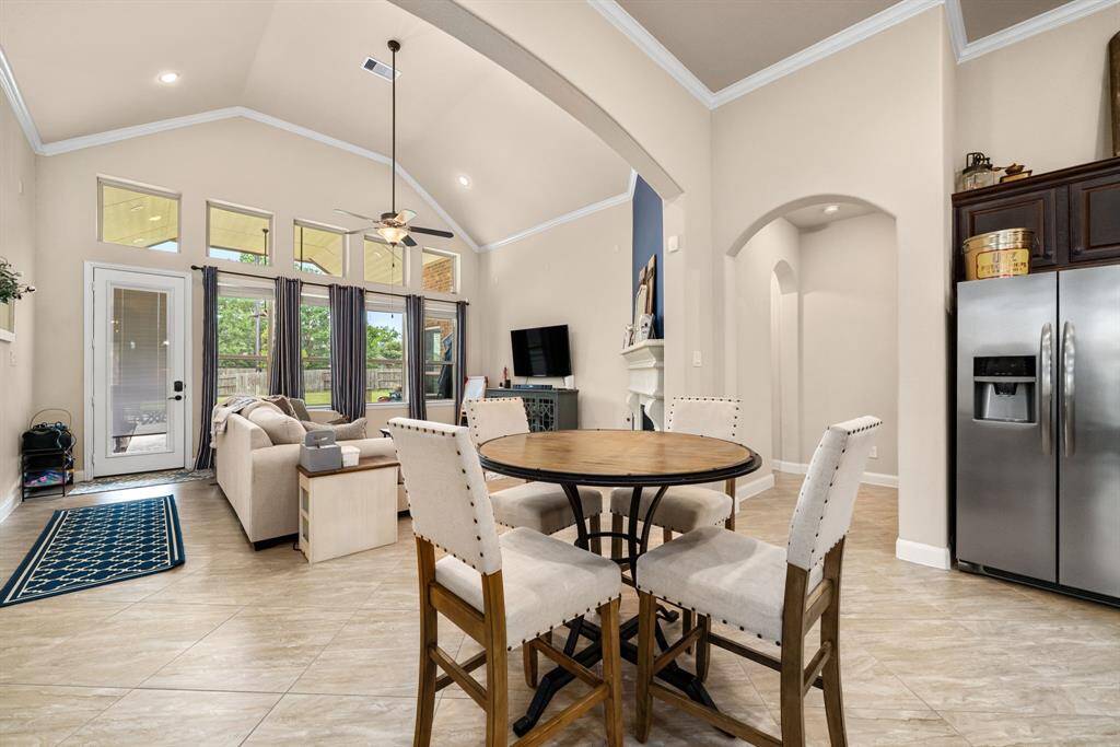 Breakfast area between the kitchen and living area is great place to share coffee or light bites as you look outside at expansive backyard with a pool and large deck.