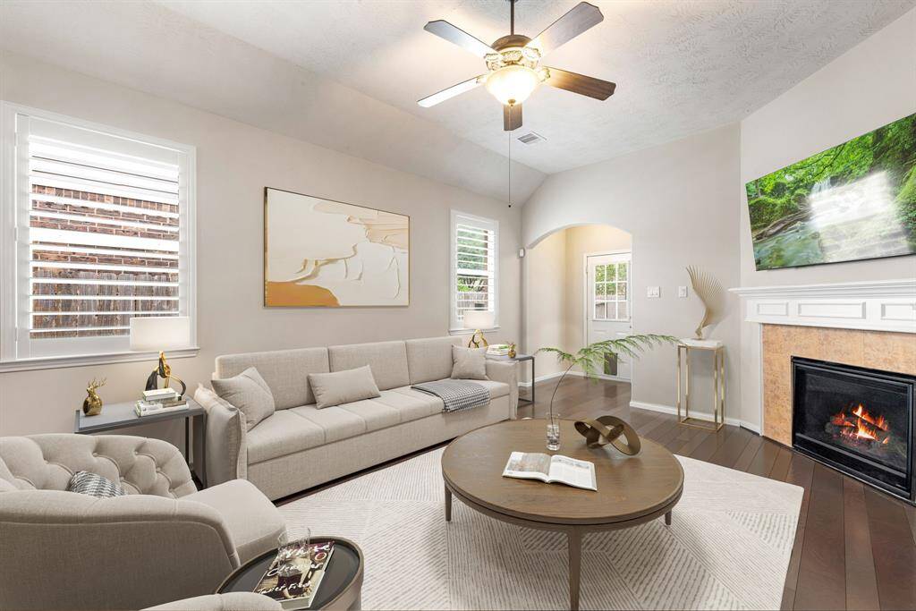 This living room is more like a GREAT room featuring a stunning fireplace with mantel detailing, custom paint, soaring high ceiling, dark stained ceiling fan, and an amazing windows providing a lovely view of your backyard to keep an eye out on the kids or pets playing. *Virtually Staged