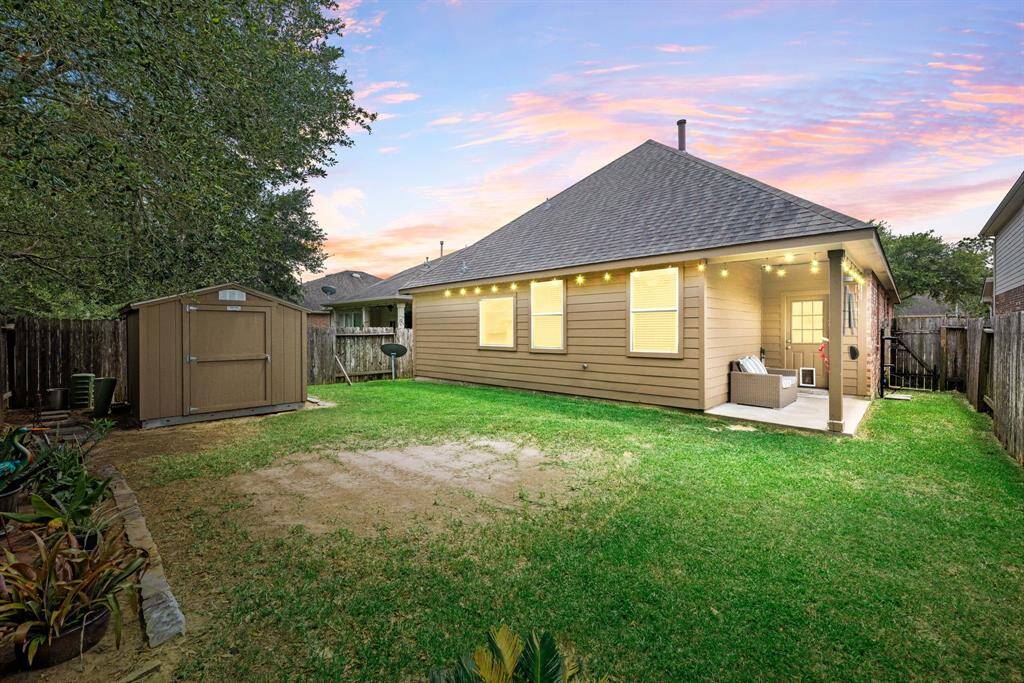 Expansive backyard offers a lush lawn and shaded patio, providing the perfect setting for weekend barbecues and playtime.