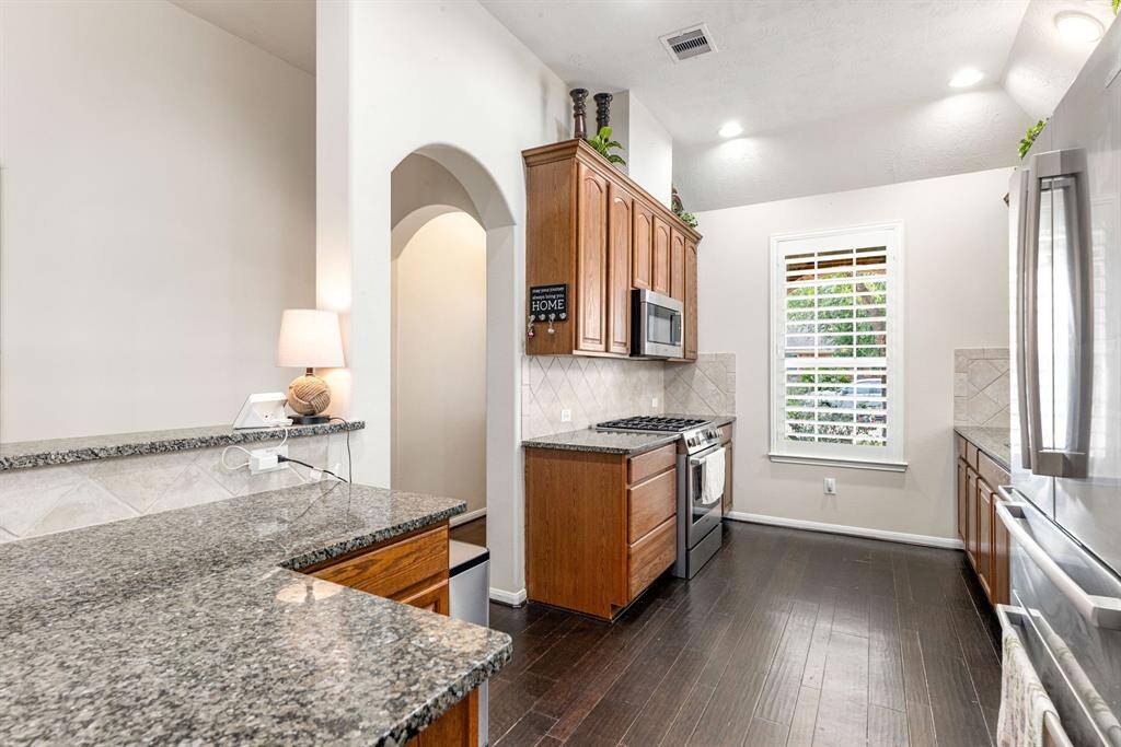 Streamlined galley-style kitchen maximizes every inch with granite counters, stainless appliances, and generous cabinet storage.