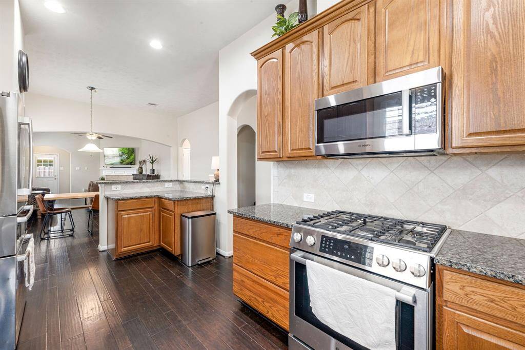 Cook, host, and mingle with ease this kitchen’s stainless stove and microwave overlook the seamless flow into the dining and living rooms.