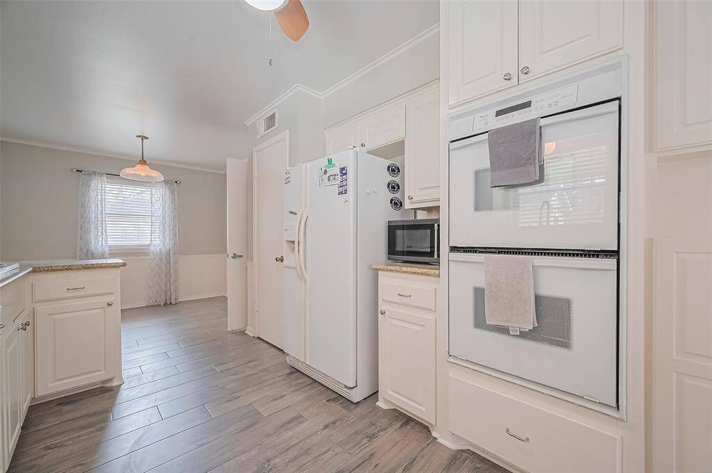 View of the kitchen, with double ovens and granite counter tops.