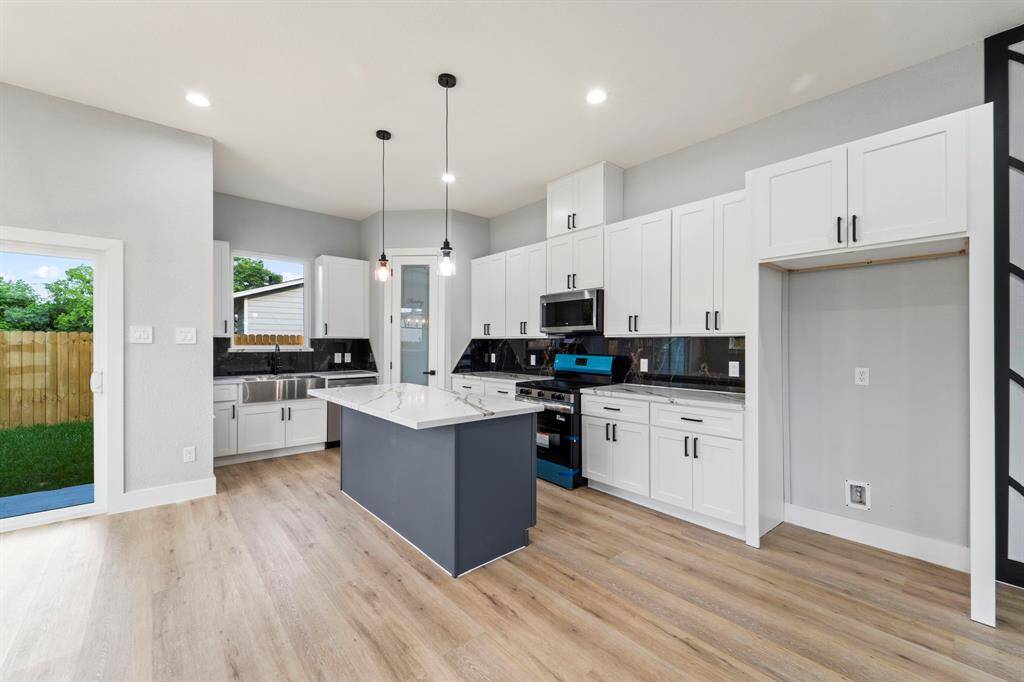 Gourmet kitchen with quartz countertops and custom backsplash