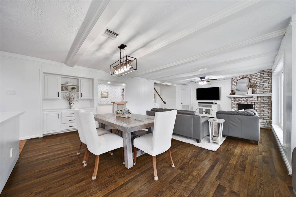 The open casual dining area between the living room and kitchen features a built-in hutch for serving and storage, complete with a light to highlight its open shelving spaces.