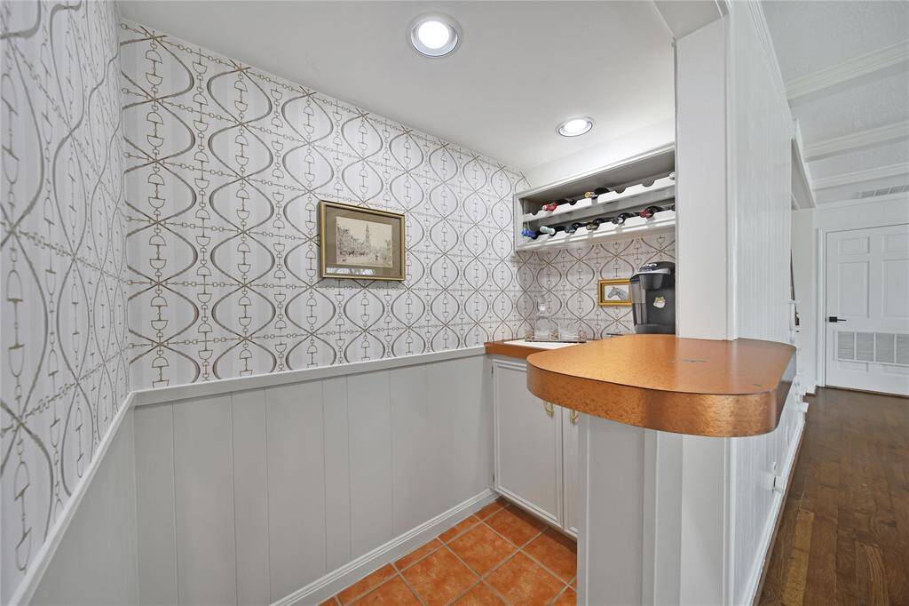 Tucked off the living room, this charming dry bar is perfect for serving drinks while entertaining or enjoying your morning coffee. With capped plumbing beneath the cabinet, you have the option to easily add a sink for even more convenience.