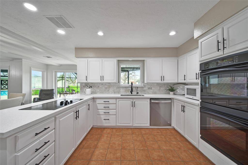 This spacious kitchen boasts abundant countertop space, perfect for meal prep, along with ample cabinetry to neatly store dishes, small appliances, and all your kitchen essentials.