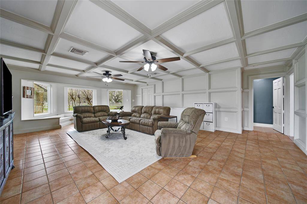 The Family Room  is one of the hidden gems of the home, having everything from the gorgeous bay windows with built-in seating overlooking the yard to the beautiful coffered ceiling. Double doors lead to a large storage closet with built ins that can be used as a mini "office: area.  Dual fans and plenty of sunlight coming through the windows means that this is the perfect room to relax and wind down.