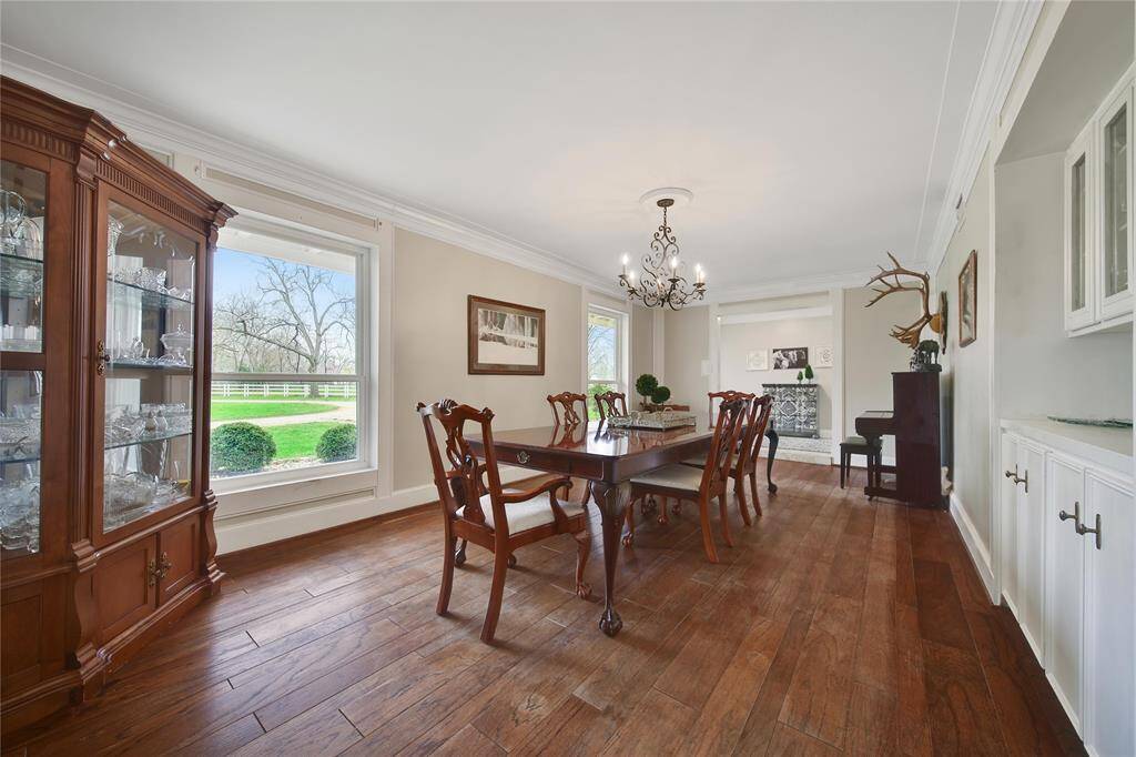 Two oversized windows looking out into the front yard let in plenty of natural sunlight, while the custom chandelier overhead will provide the perfect ambiance to an amazing home cooked Texas meal.