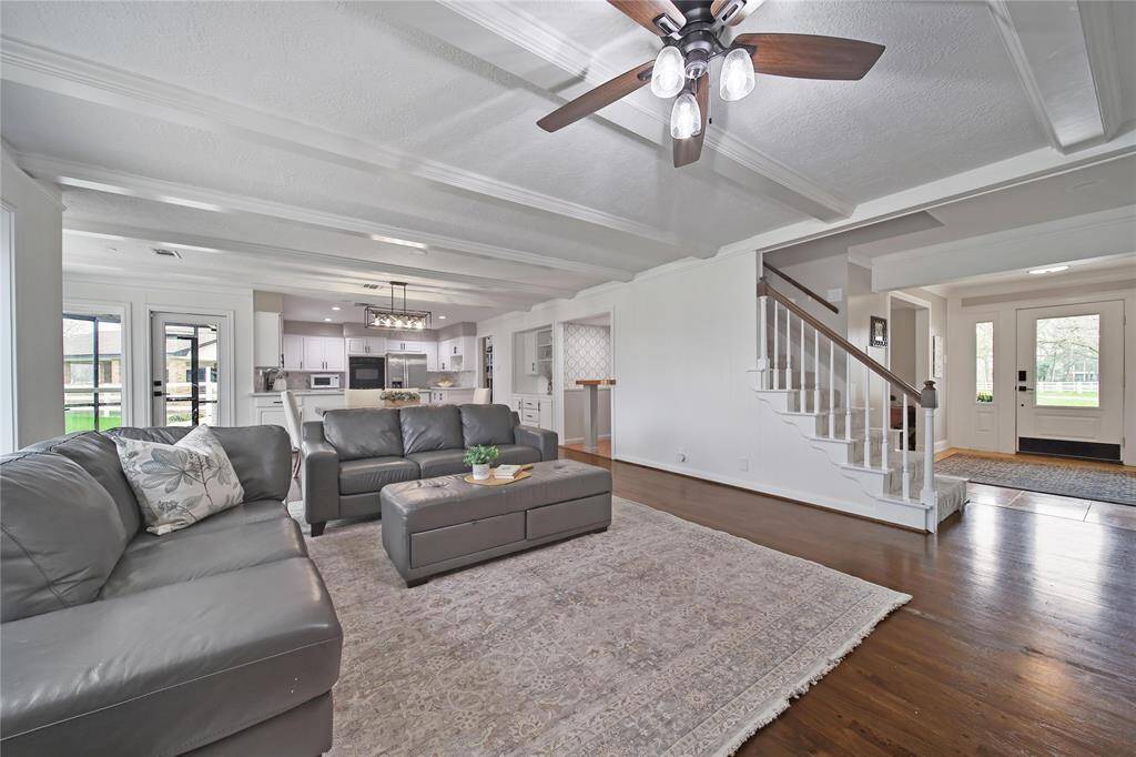 After passing the formal dining room and crossing the foyer, you enter the spacious open living area. Stairs lead to the 2nd floor where you will find the three guest bedrooms.
