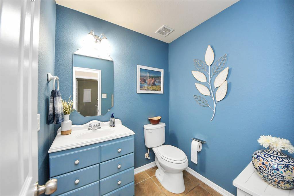 Half bath near kitchen and secondary bedroom, great for guests.