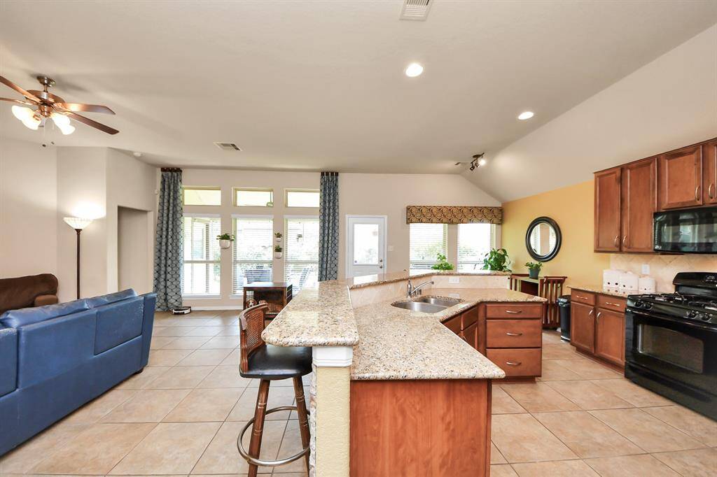 Bright kitchen featuring modern finishes and a convenient bar for quick dining.