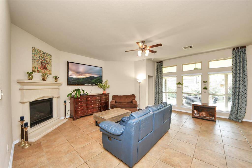 Open-concept living space with cozy fireplace—TV included.