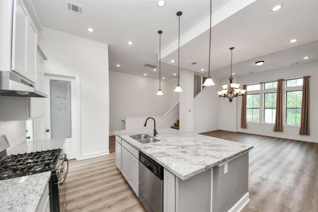 The kitchen features a central island, soft-closing cabinets and drawers, under-cabinet lighting, and a walk-in pantry.